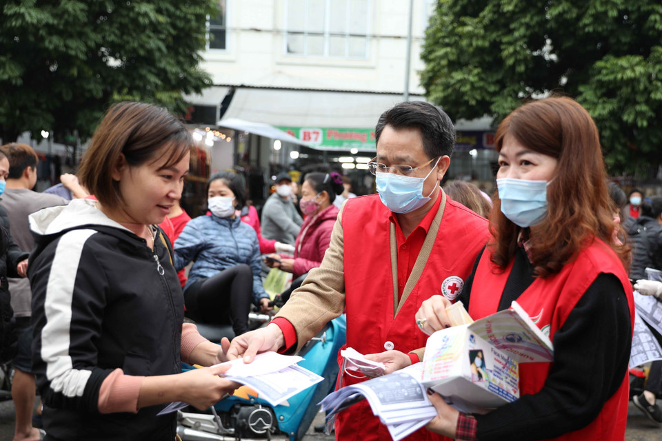 Chủ tịch Hội Chữ thập Đỏ thành phố Hà Nội Đào Ngọc Triệu tuyên truyền, phát khẩu trang cho người dân tại khu chợ Ninh Hiệp, Gia Lâm (Hà Nội). (Ảnh: Thanh Tùng/TTXVN)