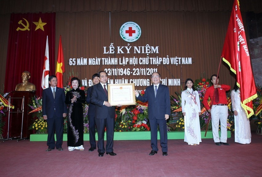 Chủ tịch Quốc hội Nguyễn Sinh Hùng trao Huân chương Hồ Chí Minh cho Hội Chữ thập Đỏ Việt Nam tại Lễ kỷ niệm 65 năm Ngày thành lập Hội (20/11/2011). (Ảnh: Nhan Sáng/TTXVN)