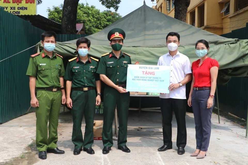 Lãnh đạo huyện Gia Lâm cùng Hội Chữ thập Đỏ huyện trao tượng trưng phần hỗ trợ tới khu cách ly tập trung phòng chống dịch COVID-19 của Học viện Nông nghiệp. (Ảnh: TTXVN phát)