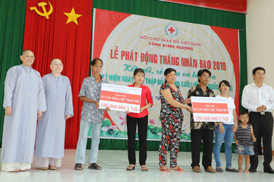 Đại diện các hộ nghèo có khó khăn về nhà ở của tỉnh Bình Dương nhận sự hỗ trợ về xây nhà Chữ thập Đỏ của các tổ chức, cá nhân có tấm lòng vàng. (Ảnh: Nguyễn Văn Việt/TTXVN)