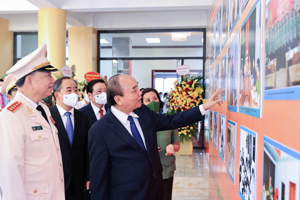 Chủ tịch nước Nguyễn Xuân Phúc tham quan trưng bày ảnh về các hoạt động của lực lượng An ninh nhân dân. (Ảnh: Thống Nhất/TTXVN)