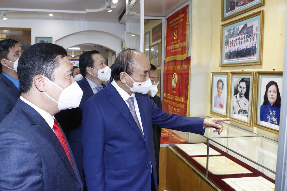 Chủ tịch nước Nguyễn Xuân Phúc thăm phòng truyền thống của Tổng công ty May 10. (Ảnh: Thống Nhất/TTXVN)