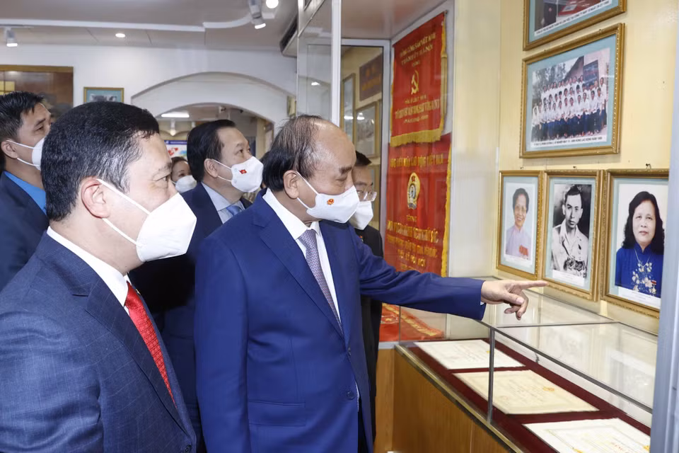 Chủ tịch nước Nguyễn Xuân Phúc thăm phòng truyền thống của Tổng công ty May 10. (Ảnh: Thống Nhất/TTXVN)