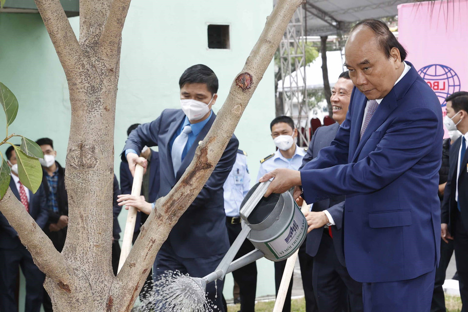 Chủ tịch nước Nguyễn Xuân Phúc thăm, trồng cây lưu niệm tại khuôn viên Tổng công ty May 10. (Ảnh: Thống Nhất/TTXVN)