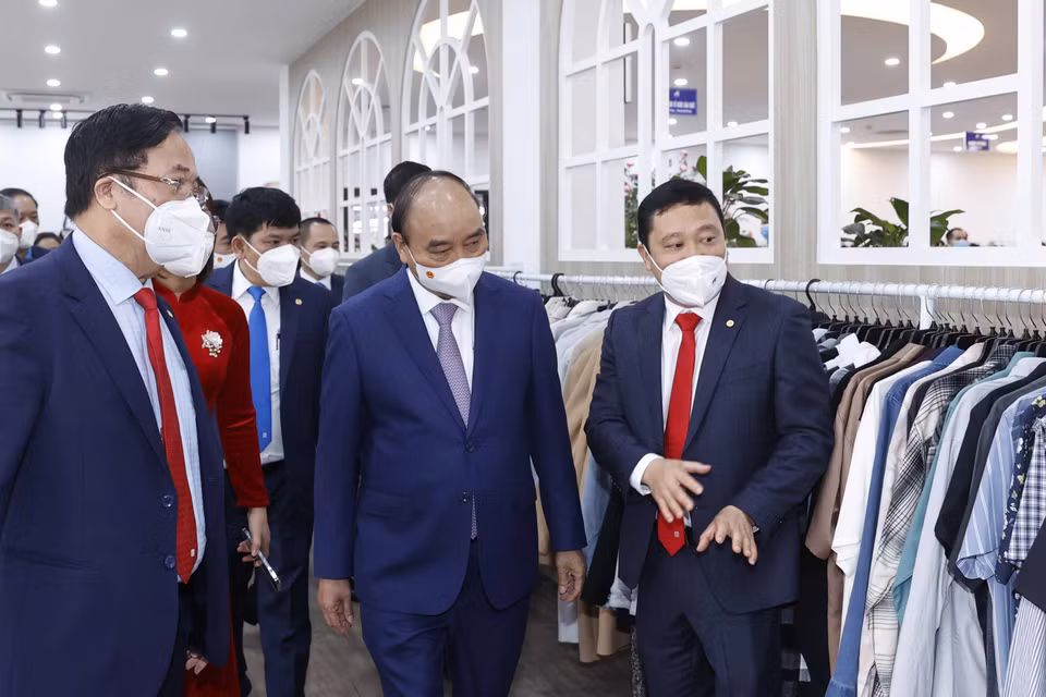 Chủ tịch nước Nguyễn Xuân Phúc thăm dây chuyền sản xuất của Tổng công ty May 10. (Ảnh: Thống Nhất/TTXVN)
