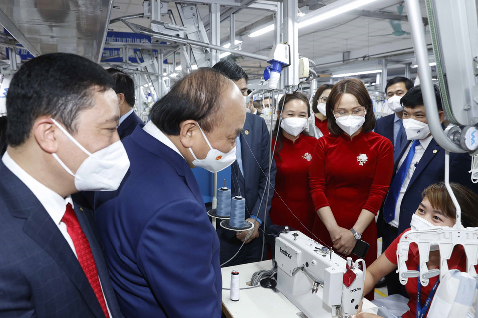 Chủ tịch nước Nguyễn Xuân Phúc thăm dây chuyền sản xuất của Tổng công ty May 10. (Ảnh: Thống Nhất/TTXVN)