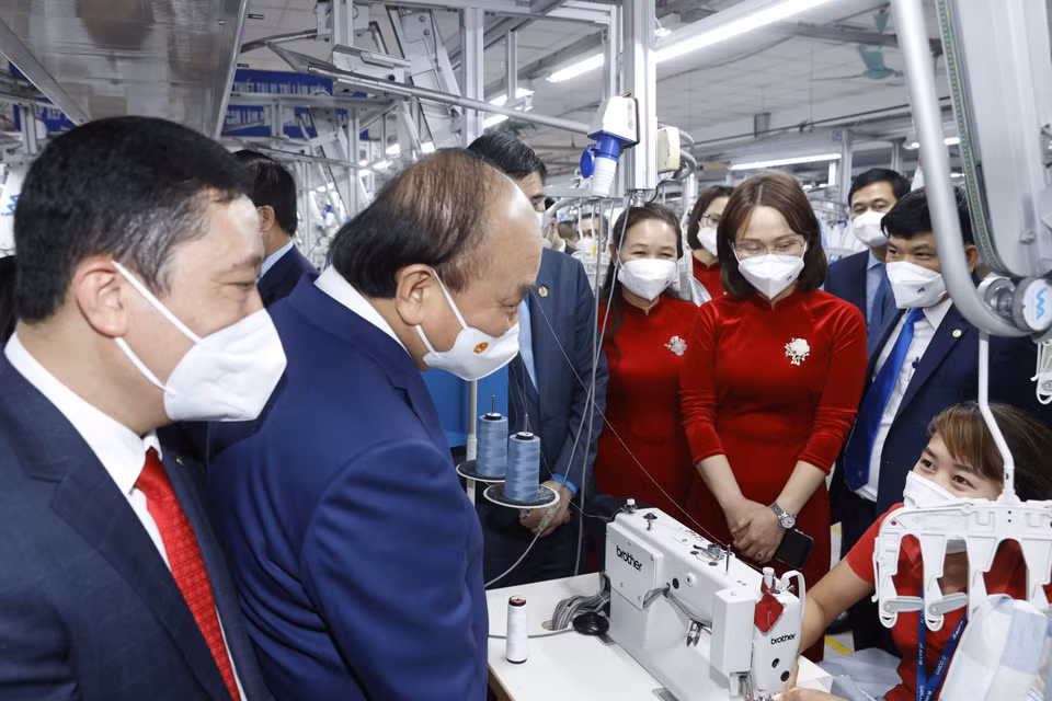 Chủ tịch nước Nguyễn Xuân Phúc thăm dây chuyền sản xuất của Tổng công ty May 10. (Ảnh: Thống Nhất/TTXVN)