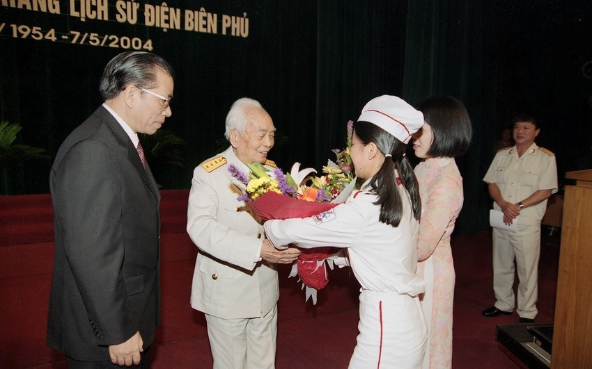 Thiếu nhi thủ đô Hà Nội tặng hoa Đại tướng Võ Nguyên Giáp tại Lễ mít tinh kỷ niệm 50 năm Chiến thắng Điện Biên Phủ, ngày 05/05/2004, tại Cung Văn hóa hữu nghị. (Ảnh: Nguyễn Khang/TTXVN)