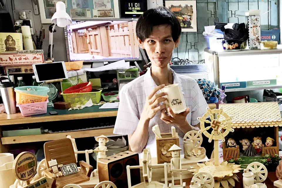 Anh Triệu Hồng Hồ Em cùng các sản phẩm thủ công từ tre. (Ảnh: Công Mạo/TTXVN)