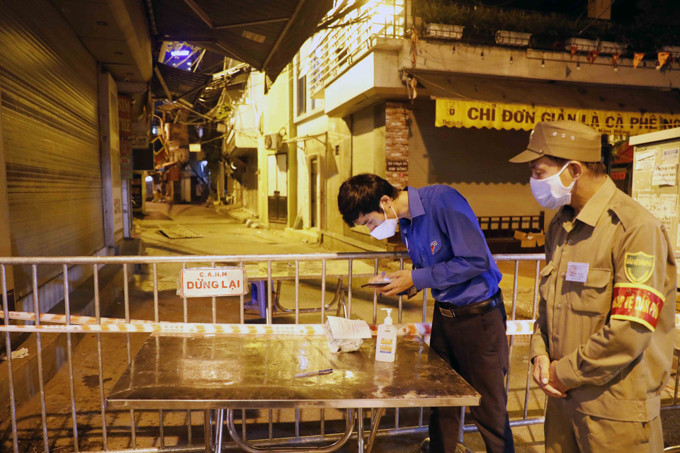 Đoàn viên thanh niên tham gia hỗ trợ chuyển hàng cho người dân tại các khu cách ly trong đêm. (Ảnh: Trần Việt/TTXVN)