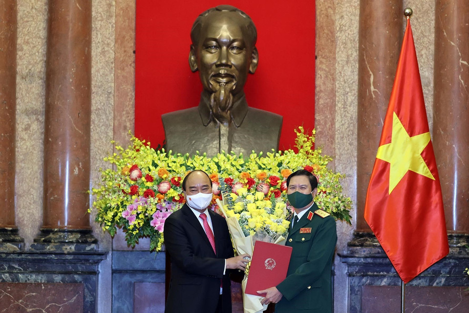 Chủ tịch nước Nguyễn Xuân Phúc tặng hoa chúc mừng Thượng tướng Nguyễn Tân Cương. (Ảnh: Thống Nhất/TTXVN)