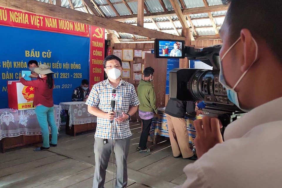 Trưởng Cơ quan Thường trú TTXVN tại tỉnh Kon Tum Hoàng Cao Nguyên và phóng viên Khoa Chương đưa tin bầu cử sớm tại điểm bầu cử số 3, thôn Măng Khênh, xã Đăk Man, huyện Đăk Glei, tỉnh Kon Tum (2021). (Ảnh: Nhân vật cung cấp)