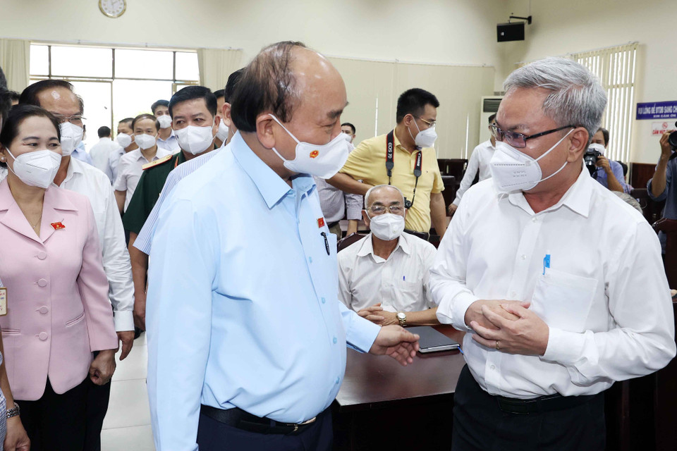 Chủ tịch nước Nguyễn Xuân Phúc trò chuyện với cử tri huyện Hóc Môn trước buổi tiếp xúc cử tri. (Ảnh: Thống Nhất/TTXVN)