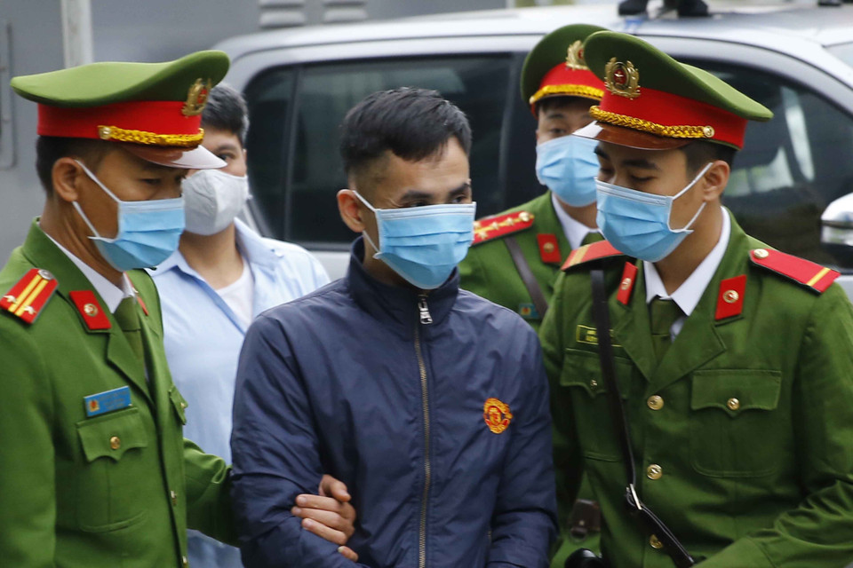 Cảnh sát dẫn giải các bị cáo vào phiên xét xử. (Ảnh: Doãn Tấn/TTXVN)