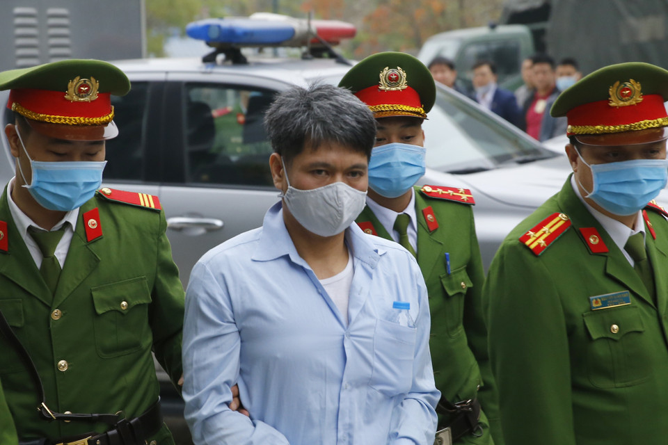 Cảnh sát dẫn giải các bị cáo vào phiên xét xử. (Ảnh: Doãn Tấn/TTXVN)