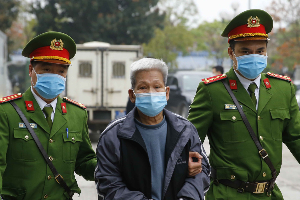 Cảnh sát dẫn giải các bị cáo vào phiên xét xử. (Ảnh: Doãn Tấn/TTXVN)