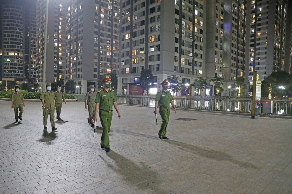 Lực lượng Công an và bảo vệ dân phố phường Vĩnh Tuy tuần tra tại khu chung cư TimeCity trong ngày thứ hai Hà Nội thực hiện giãn cách xã hội theo nguyên tắc Chỉ thị 16/CT-TTg của Thủ tướng Chính phủ để phòng, chống dịch COVID-19. (Ảnh: Trần Việt/TTXVN)