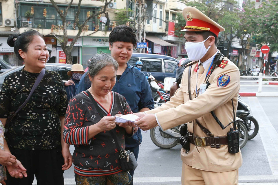 Cảnh sát giao thông Hà Nội tham gia phát khẩu trang phòng chống dịch COVID-19 cho người đi xe buýt (28/2/2020). (Ảnh: Doãn Tấn/TTXVN)