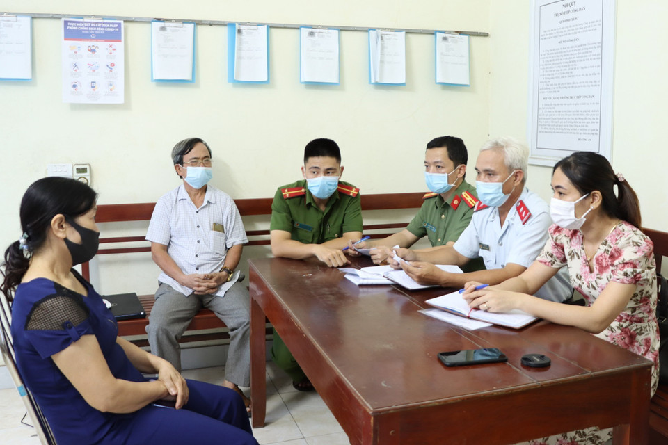 Đối tượng N.T.Tuyết (bên trái), sinh năm 1965, trú tại phường Yên Bình, thành phố Tam Điệp, tỉnh Ninh Bình tại buổi làm việc với cơ quan chức năng để làm rõ về hành vi cung cấp, chia sẻ thông tin bịa đặt trên mạng xã hội rằng “chân ngôn” Pháp Luân Công chữa khỏi bệnh COVID-19. Cơ quan chức năng đã ra quyết định xử phạt vi phạm hành chính đối tượng 10 triệu đồng và yêu cầu gỡ bỏ bài viết, cam kết không tái phạm. (Ảnh: Đức Phương/TTXVN)
