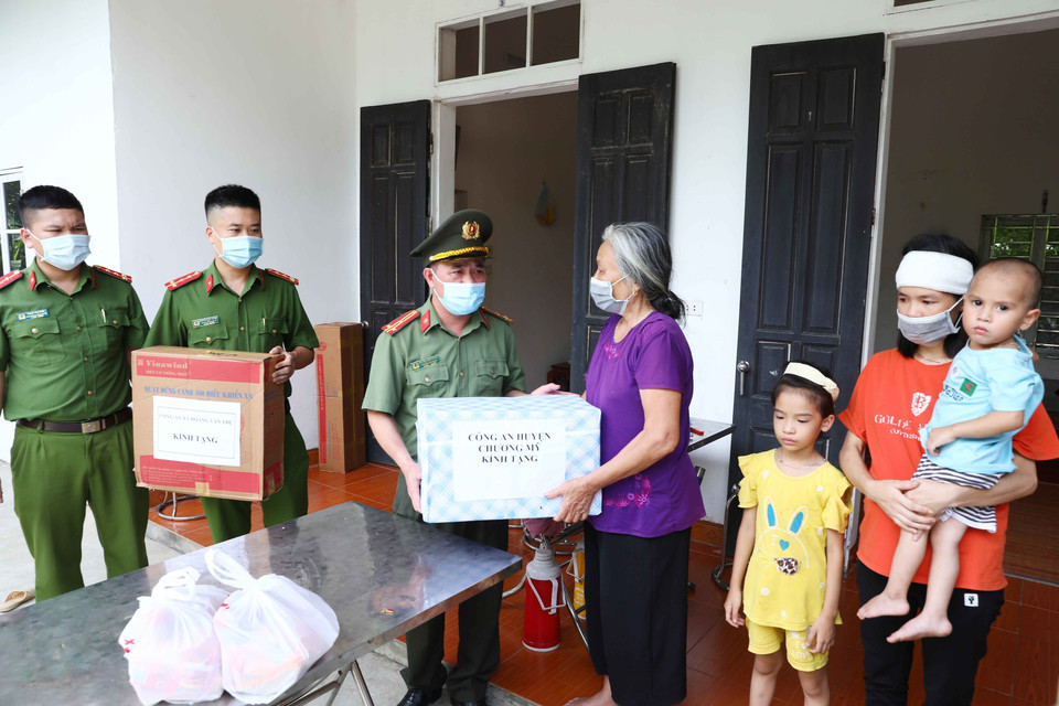 Công an huyện Chương Mỹ (Hà Nội) trao quà hỗ trợ gia đình anh Nguyễn Hữu Dương, hy sinh trong khi làm nhiệm vụ tại chốt phòng, chống dịch COVID-19. (Ảnh: Phạm Kiên/TTXVN)