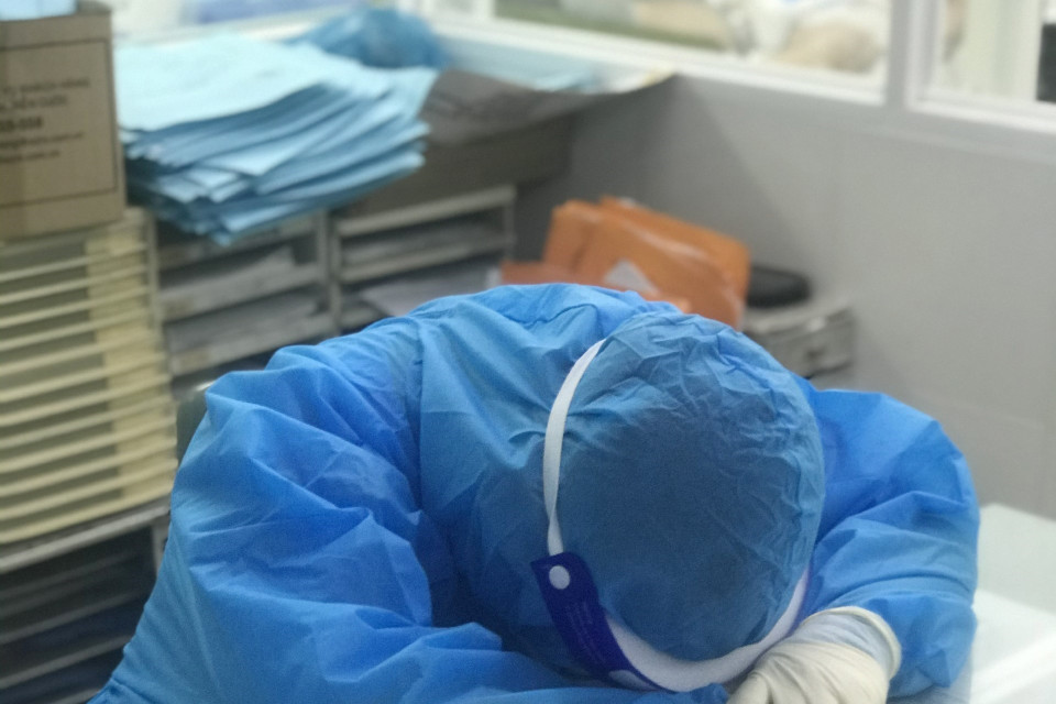 Một y, bác sỹ của Bệnh viện Dã chiến số 1 điều trị COVID-19 Khánh Hòa nằm tạm nghỉ lấy sức trên bàn làm việc. (Ảnh: TTXVN phát)