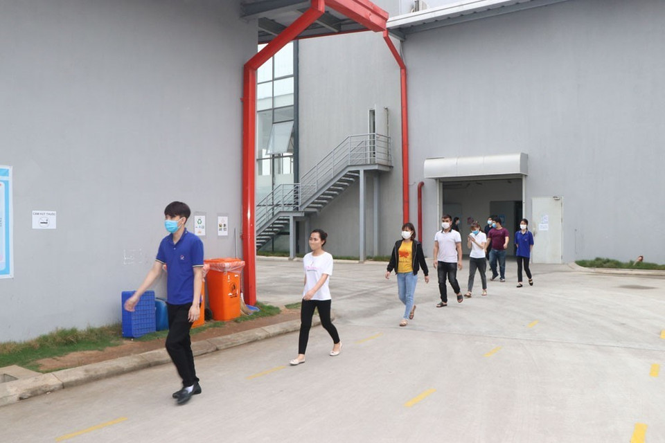 Công nhân Công ty TNHH Điện tử POYUN Việt Nam xếp hàng và giãn cách để ra nhà ăn. (Ảnh: Mạnh Minh/TTXVN)