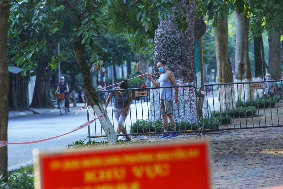 Nhiều người dân vẫn tập thể dục tại khu vực hồ Thiền Quang dù đã được lực lượng chức năng căng dây, cắm biển cấm (ảnh chụp lúc 6h20p ngày 13/7). (Ảnh: Hoàng Hiếu/TTXVN)