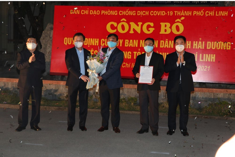 Lãnh đạo tỉnh Hải Dương trao quyết định của Ủy ban Nhân dân tỉnh về gỡ bỏ phong tỏa thành phố Chí Linh. (Ảnh: Mạnh Minh/TTXVN)