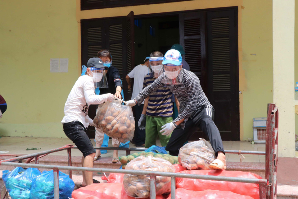 Đội ngũ tình nguyện viên chuyển thực phẩm từ các nhà tài trợ mang đến phát cho người dân tại xã Mão Điền (Bắc Ninh) đang thực hiện cách ly xã hội để phòng, chống dịch. (Ảnh: Thanh Thương/TTXVN)