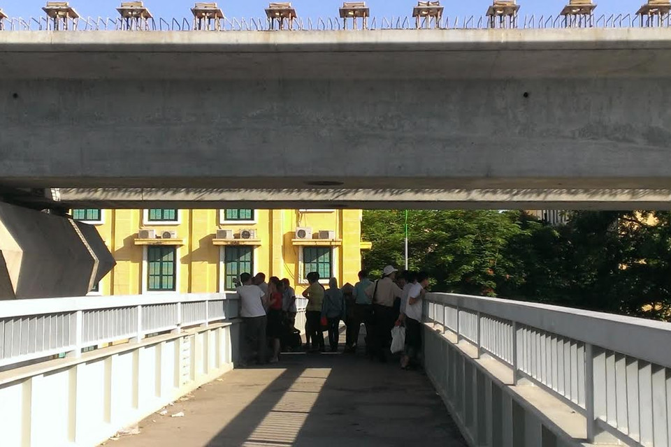 Không có bóng cây như tại Đại học Sư phạm Hà Nội, tại trường Đại học Khoa học Xã hội và Nhân văn, phụ huynh phải tận dụng bóng râm ít ỏi từ đường cao tốc trên cao chiếu xuống cầu vượt dành cho người đi bộ. (Ảnh: Phạm Mai/Vietnam)