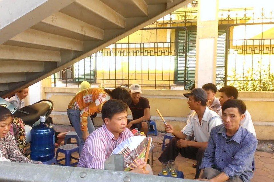 Bóng râm hiếm hoi dưới chân cầu vượt dành cho người đi bộ được tận dụng để bán nước, làm điểm chờ cho phụ huynh. (Ảnh: Phạm Mai/Vietnam+)