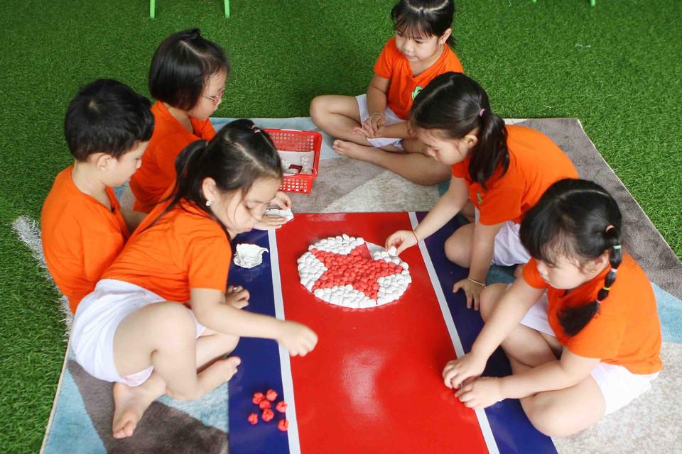 Các bé cùng vẽ, trang trí cờ hai nước Việt Nam-Triều Tiên. (Ảnh: Thanh Tùng/TTXVN)