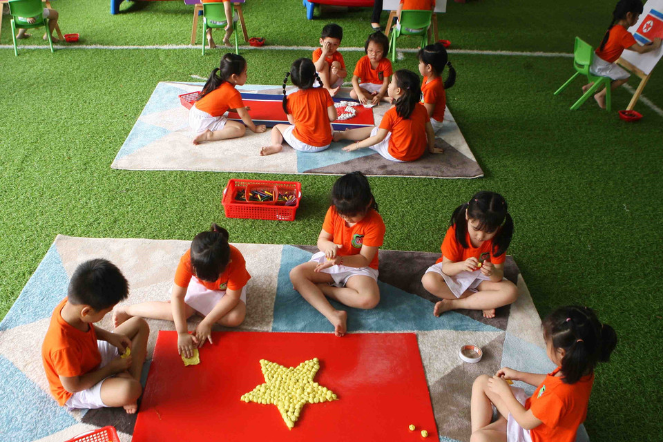 Các bé cùng vẽ, trang trí cờ hai nước Việt Nam-Triều Tiên. (Ảnh: Thanh Tùng/TTXVN)