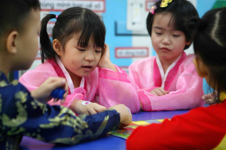 Các bé thích thú khi được mặc trang phục truyền thống của Triều Tiên. (Ảnh: Thanh Tùng/TTXVN)