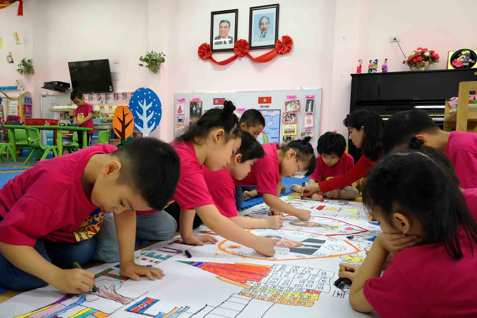 Cô và trò lớp học mang tên Kim Nhật Thành cùng hoàn thành bức tranh về chủ đề tình hữu nghị Việt Nam-Triều Tiên. (Ảnh: Thanh Tùng/TTXVN)