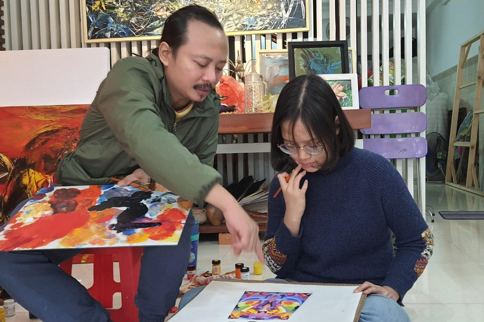 Họa sỹ Ngô Thanh Hùng dạy học sinh vẽ tại nhà. (Ảnh: Văn Dũng/TTXVN)