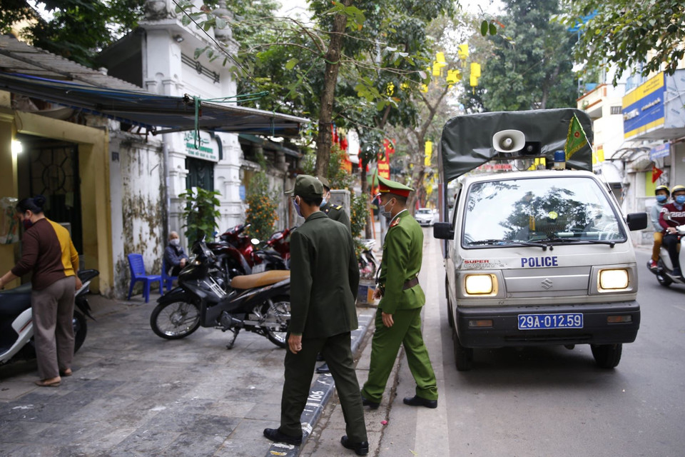 Lực lượng chức năng công an phường Hàng Mã ra quân đề nghị các hộ kinh doanh đóng cửa quán ăn đường phố, trà đá, càphê. (Ảnh: Doãn Tấn/TTXVN)