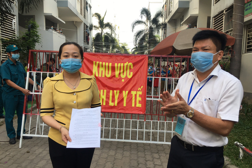 Lãnh đạo Ủy ban nhân dân phường Vĩnh Phú công bố quyết định dỡ bỏ phong tỏa khu C2, Khu dân cư Ehome4. (Ảnh: Văn Hướng/TTXVN)