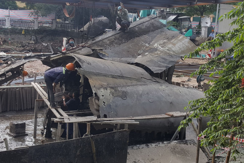 Đơn vị thi công tiến hành móc cẩu xác máy bay B52 ra khỏi vị trí cũ. (Ảnh: Đinh Thuận/TTXVN)