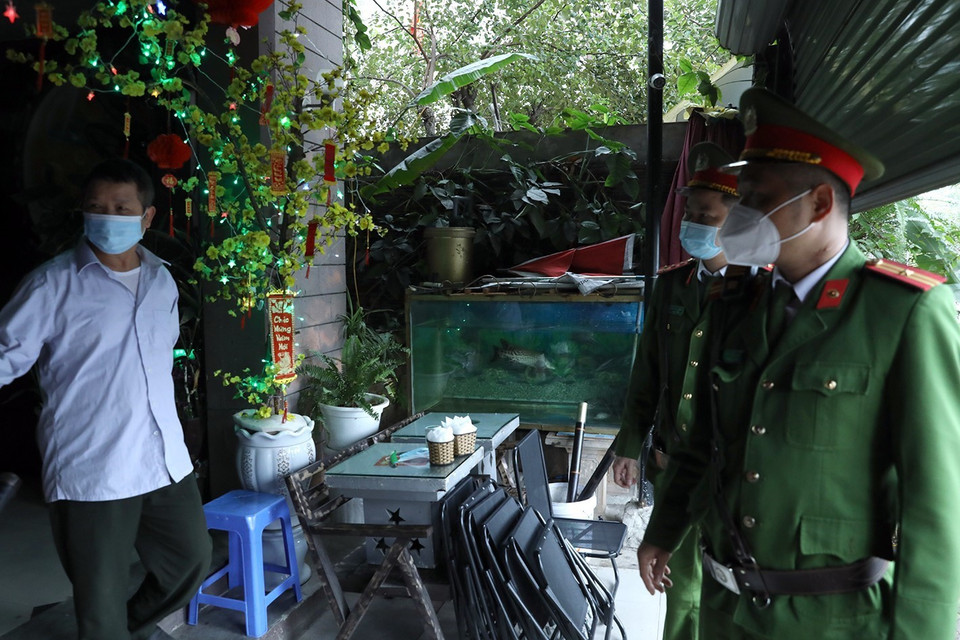 Lực lượng công an nhắc nhở người dân việc thực hiện đóng cửa quán càphê tại khu đô thị Văn Quán, quận Hà Đông. (Ảnh: Phan Tuấn Anh/TTXVN)