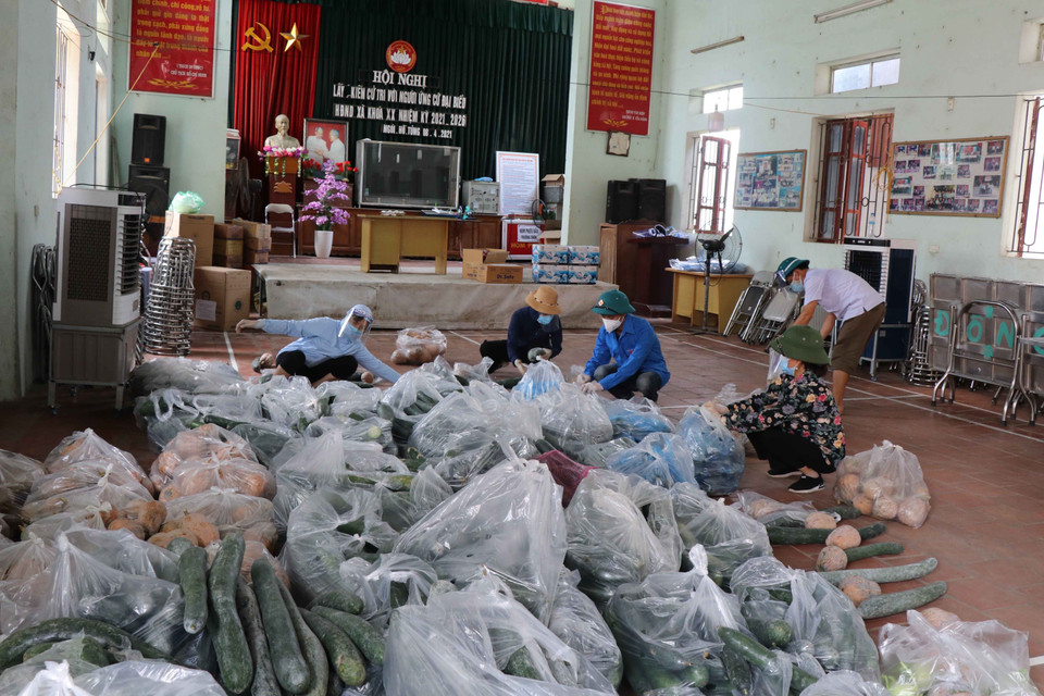 Các tình nguyện viên chia thực phẩm chuẩn bị cho người dân tại xã Mão Điền. (Ảnh: Thanh Thương/TTXVN)