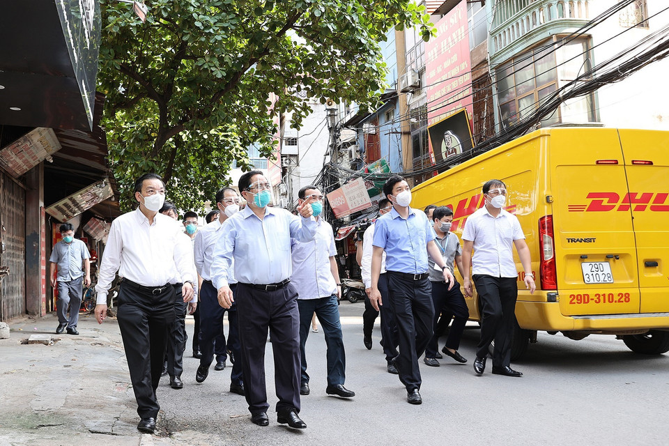 Thủ tướng Phạm Minh Chính và đoàn công tác đi kiểm tra đột xuất công tác phòng, chống dịch ở một số điểm nóng về dịch bệnh COVID-19 tại Hà Nội. (Ảnh: Dương Giang/TTXVN)