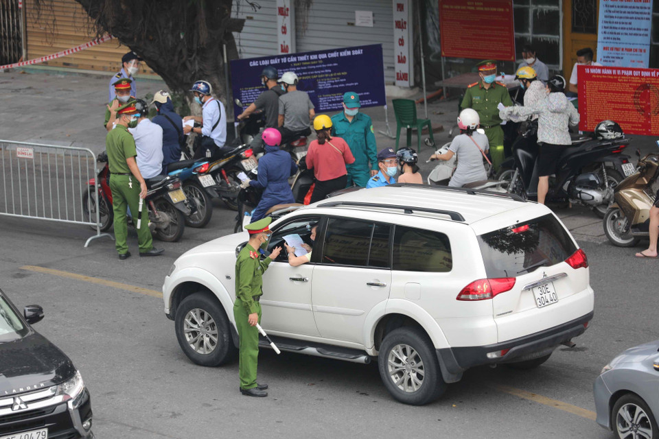 Kiểm tra giấy tờ, thông tin của người lưu thông trên phố tại chốt kiểm soát phòng chống dịch trên phố Lò Đúc (quận Hai Bà Trưng). (Ảnh: Thanh Tùng/TTXVN)