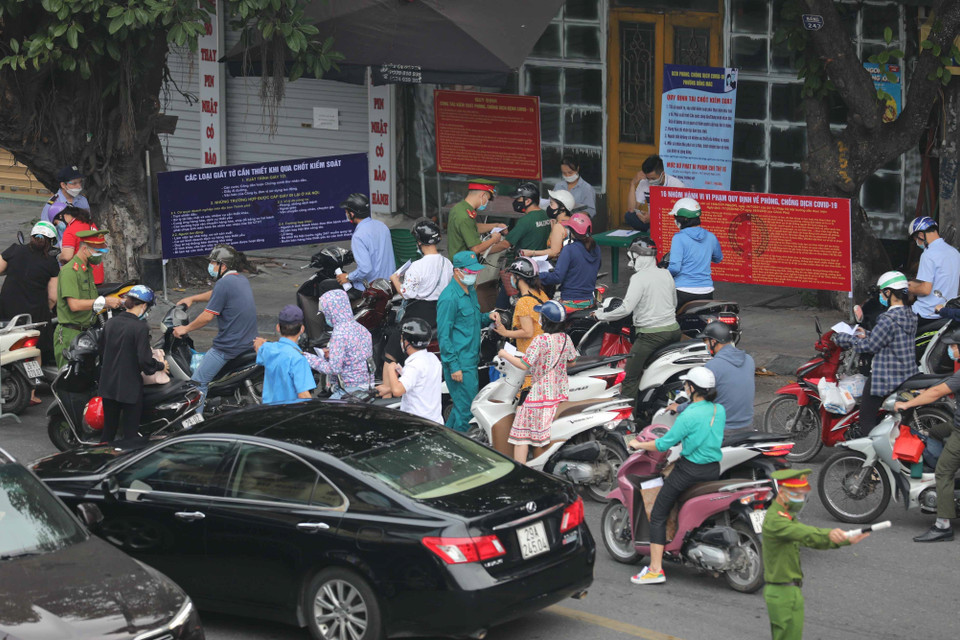 Kiểm tra giấy tờ, thông tin của người lưu thông qua chốt kiểm soát phòng chống dịch trên phố Lò Đúc (quận Hai Bà Trưng). (Ảnh: Thanh Tùng/TTXVN)