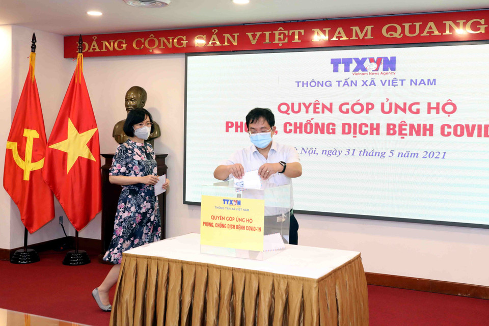 Phó Tổng Giám đốc TTXVN Nguyễn Tuấn Hùng quyên góp, ủng hộ Quỹ phòng, chống dịch COVID-19. (Ảnh: Phạm Kiên/TTXVN)