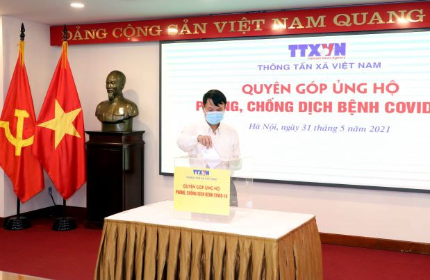 Tổng Giám đốc TTXVN Nguyễn Đức Lợi quyên góp, ủng hộ Quỹ phòng, chống dịch COVID-19. (Ảnh: Phạm Kiên/TTXVN)