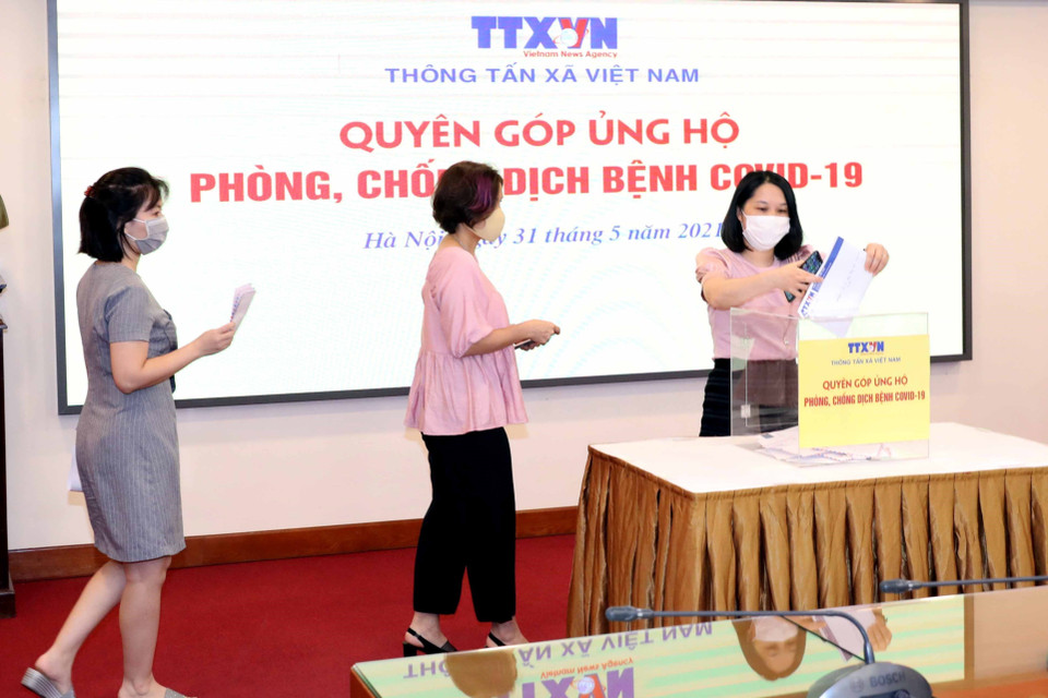 Lãnh đạo, cán bộ, phóng viên, biên tập viên và người lao động của Thông tấn xã Việt Nam tham gia quyên góp, ủng hộ Quỹ phòng, chống dịch COVID-19. (Ảnh: Phạm Kiên/TTXVN)