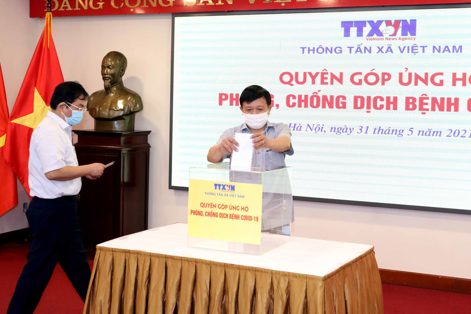 Phó Tổng Giám đốc, Chủ tịch Công đoàn TTXVN Đinh Đăng Quang quyên góp, ủng hộ Quỹ phòng, chống dịch COVID-19. (Ảnh: Phạm Kiên/TTXVN)
