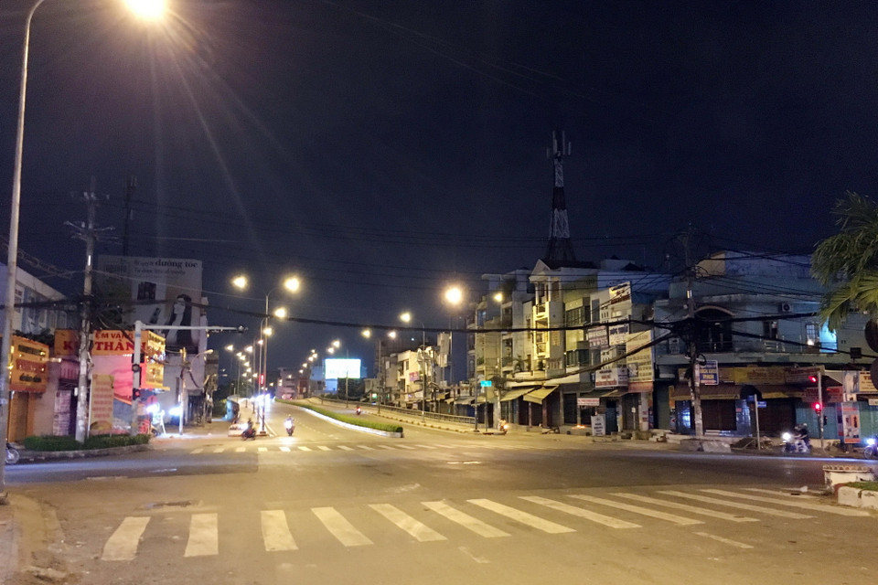 Ngã tư chợ Cầu (nút giao đường Tô Ký-Nguyễn Văn Quá) lúc 22 giờ ngày 30/5, 'cửa ngõ' hướng vào quận Gò Vấp khá vắng vẻ trước giờ giãn cách xã hội. (Ảnh: Tiến Lực/TTXVN)