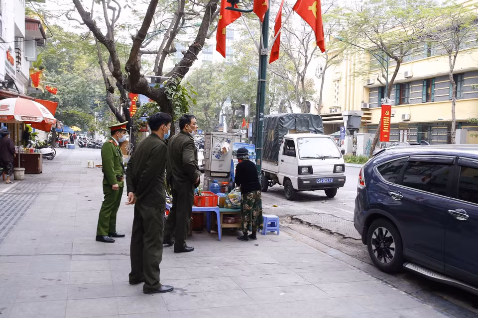Lực lượng chức năng công an phường Cửa Nam ra quân đề nghị các hộ kinh doanh đóng cửa quán ăn đường phố, trà đá, cà phê. (Ảnh: Doãn Tấn/TTXVN)
